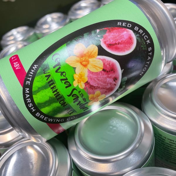 A Red Brick Station Cerveza Sandia Watermelon Ale can with a green label featuring watermelon slices and flowers.