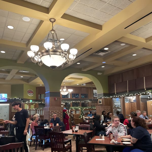 Diners seated at tables in the spacious, warmly lit interior of Red Brick Station restaurant.